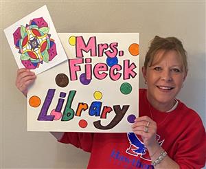 Librarian holding a sign with her name on it 